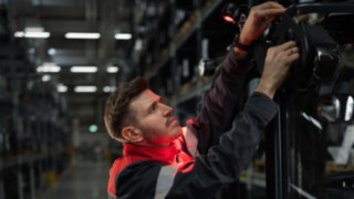 Licht- und Warnsysteme von Linde Material Handling ermöglichen ein sicheres, präzises Handling. Linde Servicetechniker bei der Montage einer Lichtlösung