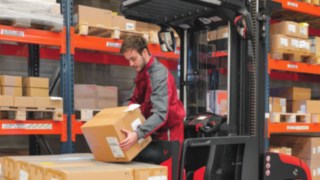 Ein Kommissionier-Mitarbeiter legt eine Warensendung ab.