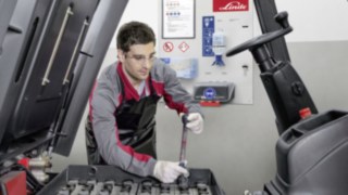 Profitieren Sie von einem Fullservice-Vertrag für das Energiesystem Ihres Linde Gebrauchtstaplers Ein Servicetechniker überprüft die Antriebsbatterie eines Linde Gebrauchtstaplers