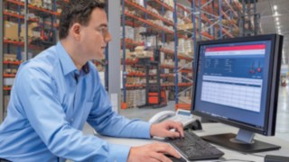 Mann arbeitet am Rechner. Person betrachtet Auswertungen auf einem Bildschirm.