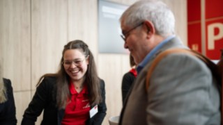 Mitarbeiterin von Linde Material Handling lacht mit einem Besucher des Linde Automation Summit.