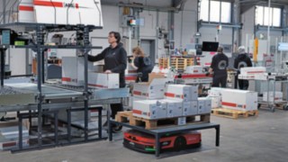 Produktionslager bei ABS Safety: AMR Linde C-MATIC und Mitarbeitende arbeiten Hand in Hand