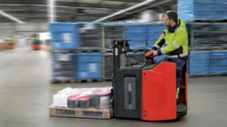 Bediener fährt mit Hochhubwagen D12 HP von Linde MH durch ein Lager