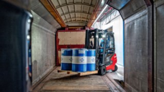 Elektrostapler Linde Xi20 P fährt mit Fässern in einen Waggon