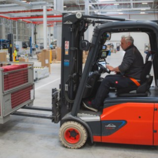 Ein Linde Elektrostapler transportiert eine Gitterbox Ein Linde Elektrostapler transportiert eine Gitterbox