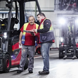 Zwei Mitarbeiter beim Automobilzulieferer SMP stehen neben einem Linde Gegengewichtsstapler