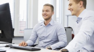 Besprechung von Linde Mitarbeitern am Schreibtisch mit Computer Besprechung von Linde Mitarbeitern am Schreibtisch mit Computer