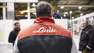 Mitarbeiter von Linde trägt das Linde Logo auf seiner Jacke