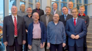 Ehrengäste: Elf der Jubilare, die für ihre 40-jährige Betriebszugehörigkeit gewürdigt wurden, mit Theodor Maurer, Vorsitzender der Geschäftsleitung von Linde Material Handling, im Treppenhaus der Stadthalle.