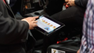 Besucher der LogiMAT 2019 lernen das Thema Linde Safety Guard kennen. Besucher auf der LogiMAT 2019 testen auf einem Tablet eine Linde App zum Thema Safety Guard.