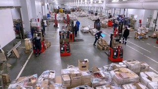Mitarbeiter in einem Kühllager. Dazu der Schriftzug "Safety & Energy Efficieny at -22°C. Warehouse solutions for the wholesaler Passion Froid."