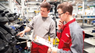 Zwei Auszubildende von Linde Material Handling in der Lagerhalle 