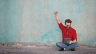 Mann mit Tablet meldet sich für Linde MH Newsletter an