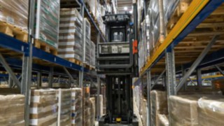 Der automatisierte Schmalgangstapler Linde K-MATIC durchfährt einen Regalgang.
